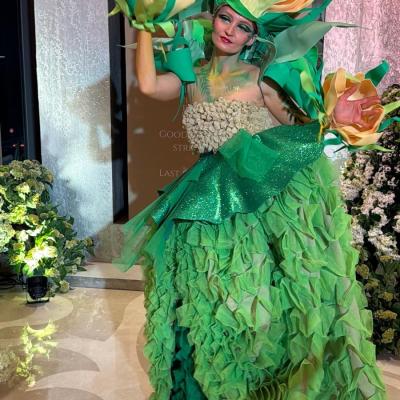 Aufwendiges Event-Make-up und Kostüm in Grün mit floralen Elementen, kreative Performance-Kunst