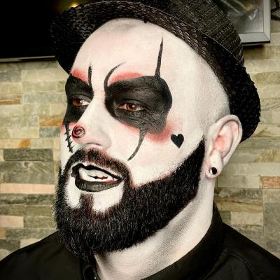 Kreatives Halloween Facepainting mit schwarz-weißem Clown-Make-up und grafischen Details