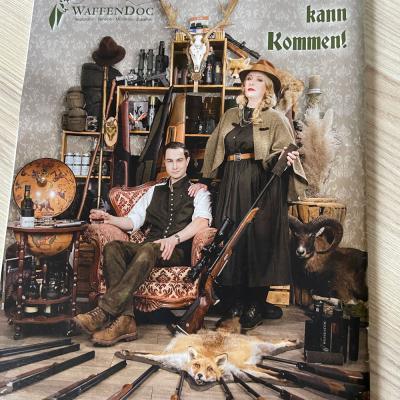 Werbeplakat für WaffenDoc mit Jagdausrüstung, Gewehren und Paar in rustikalem Setting