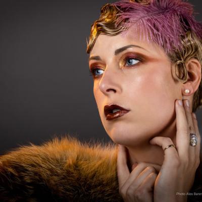 Porträt einer Frau im Retro-Look mit Federaccessoire und warmem Studiolicht