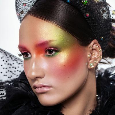Frau mit kreativem, farbenfrohem Avantgarde-Make-up und auffälligem Headpiece