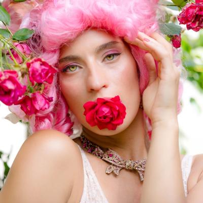 Künstlerisches Make-up mit pinken Haaren und Rosen, verspielte Beauty-Inszenierung