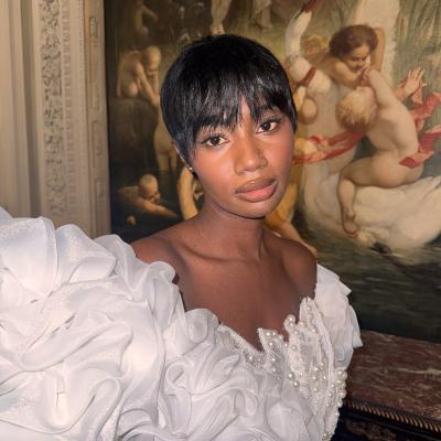 Make-Up Frau im eleganten weißen Kleid mit Rüschen vor klassischem Gemälde in stilvollem Interieur