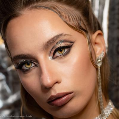 Detailporträt mit ausdrucksstarkem Augen-Make-up und glänzender Haut im Studio